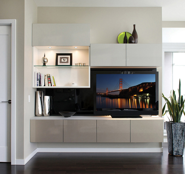 A living room media centre with TV, and sleek floating cabinets.