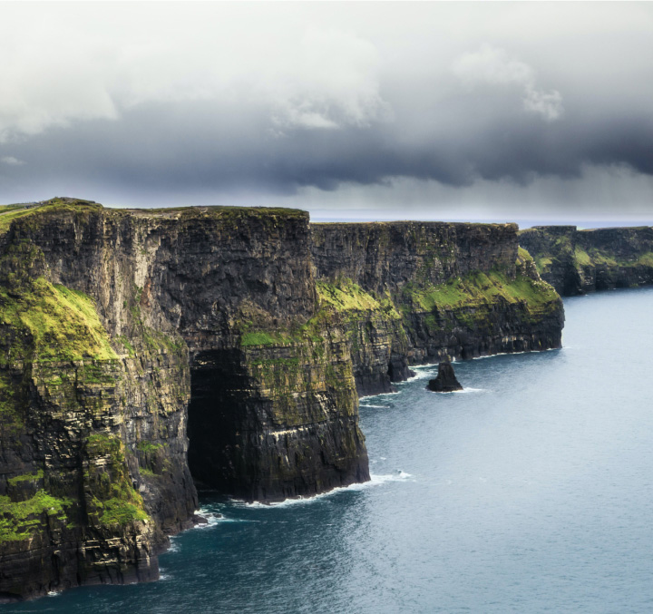 The cliffs of Mother in Ireland recede into a cloudy grey sky.