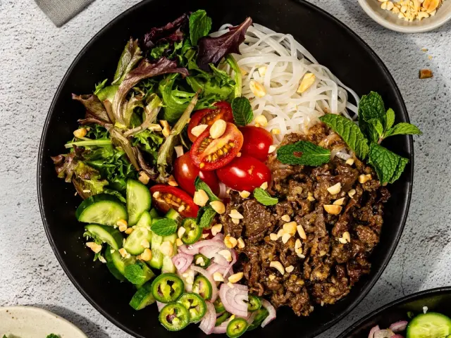 Delicious rice bowl topped with colorful vegetables, protein, and flavorful sauces, served in a ceramic bowl and ready to be enjoyed as a wholesome and satisfying meal.