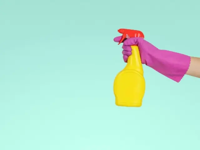 Person applying cleaner with a spray bottle, diligently tidying up and maintaining cleanliness in their living space.