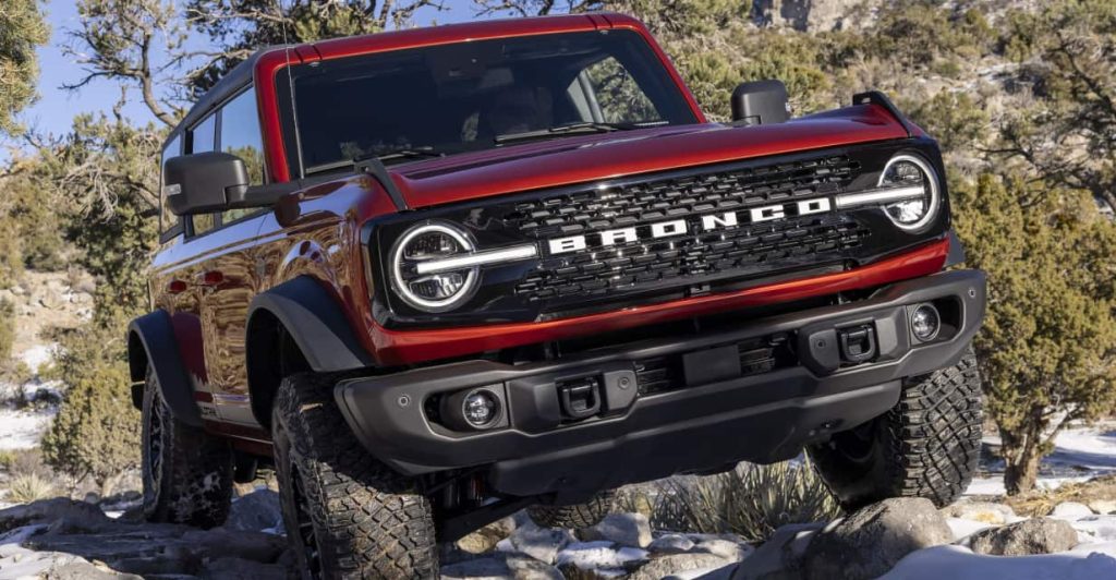 Red Ford Bronco parked in a rugged environment, showcasing its bold design and rugged capabilities